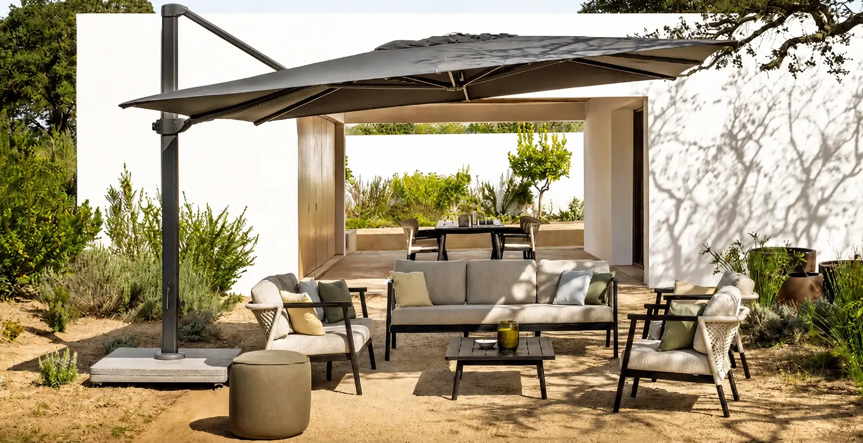 Outdoor lounge beneath a cantilevered parasol in a Mediterranean garden