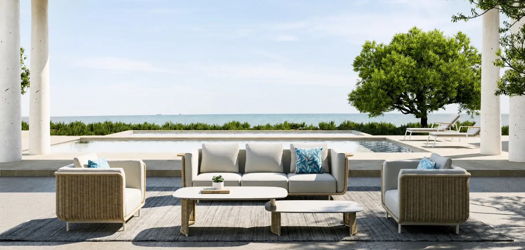 White outdoor sofas beside a pool with a view of the sea