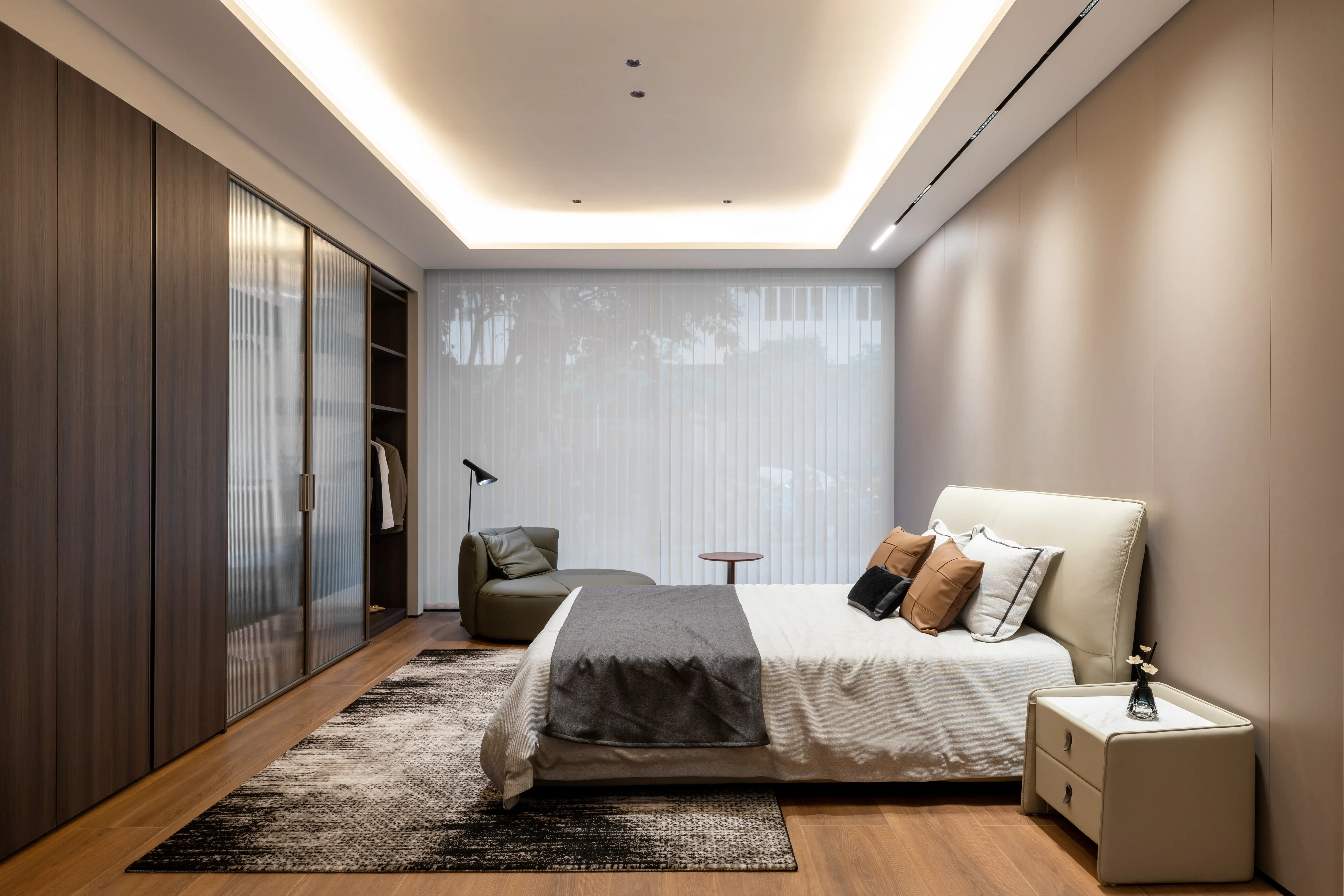 Bedroom with walnut wardrobe wall and layered grey bedding