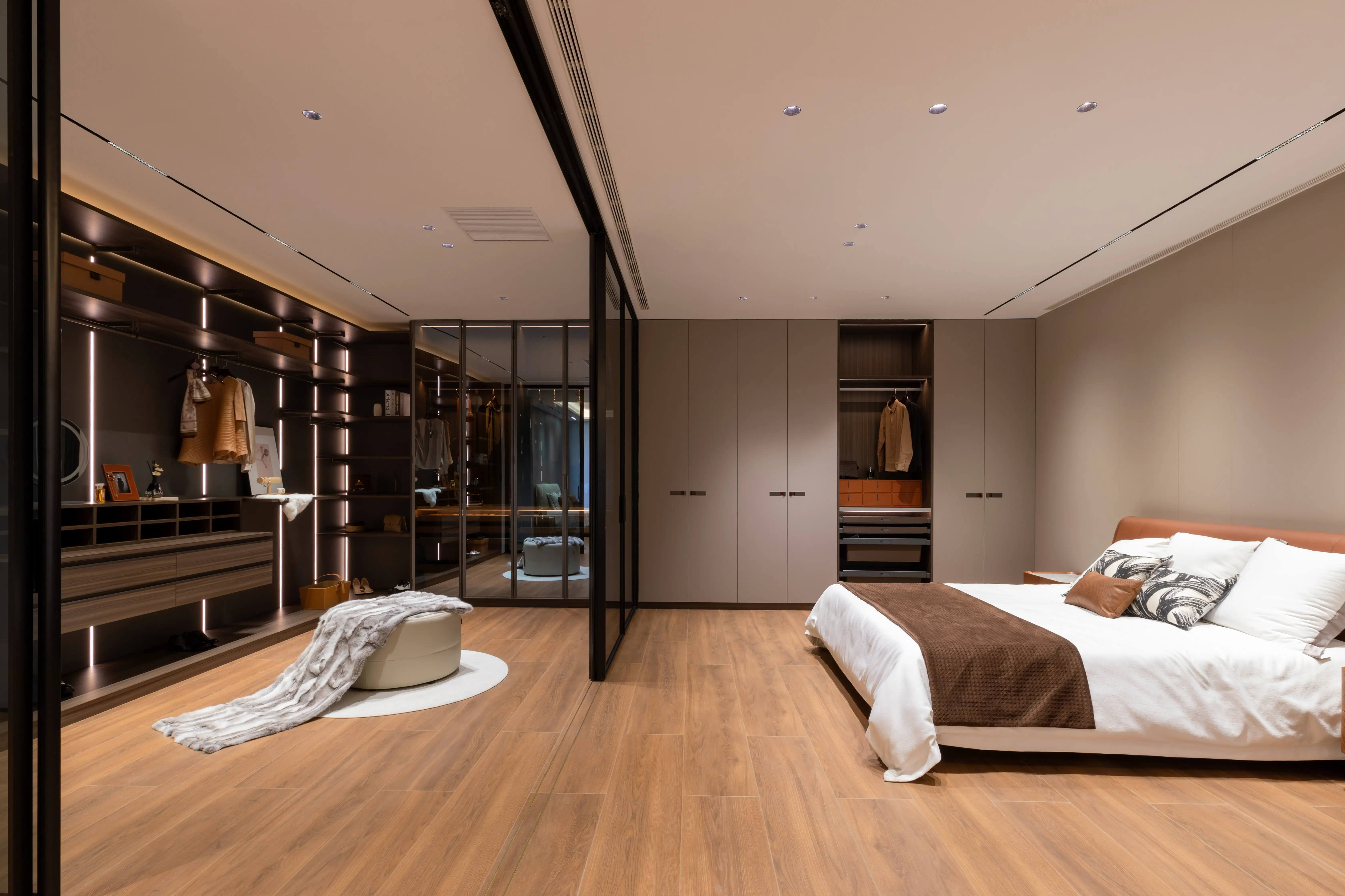 Bedroom with glass-walled dressing room and white bedding