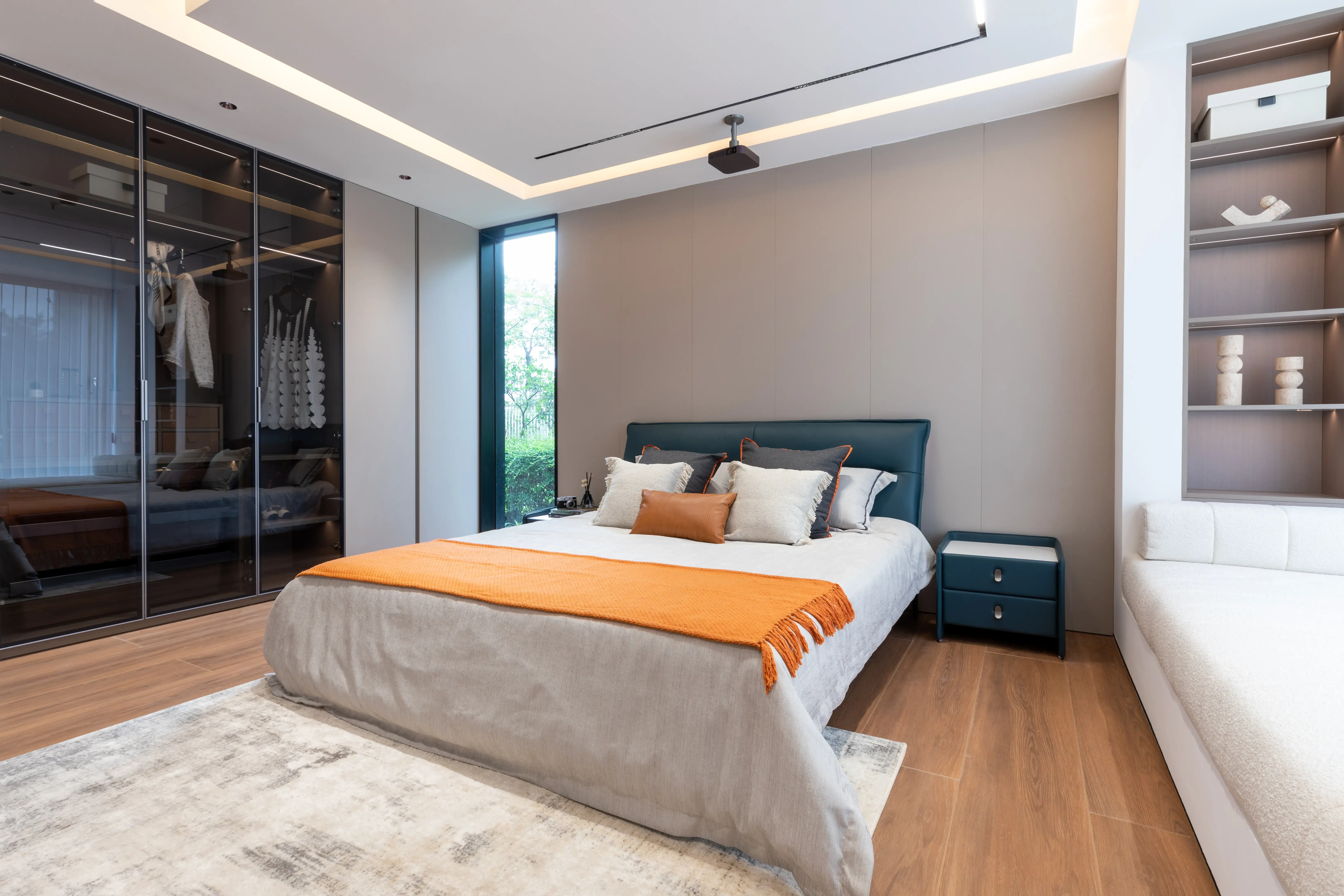 Bedroom with soft blue headboard and amber accent cushions