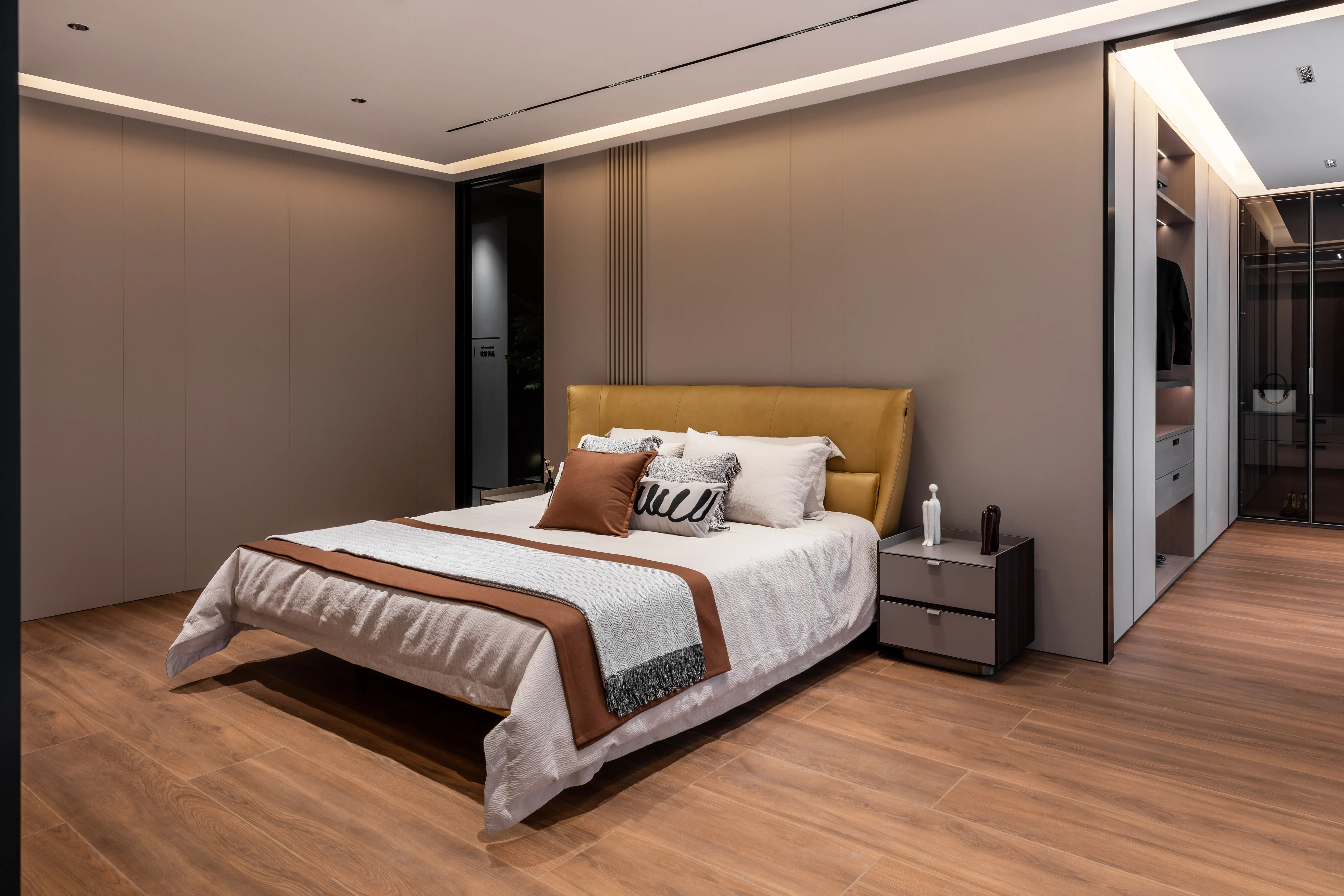 Bedroom with honey-toned headboard and patterned bedding