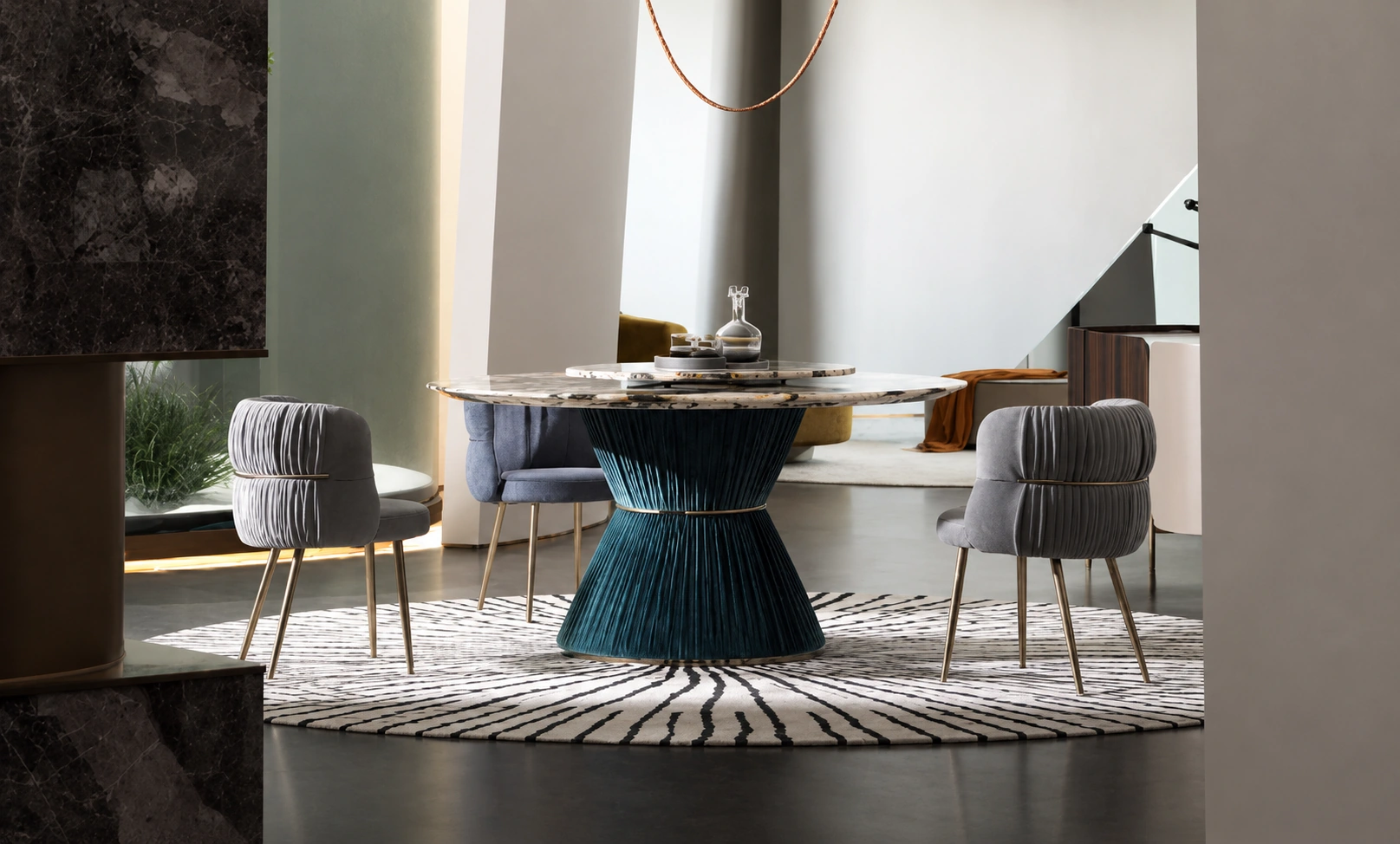 Round marble dining table on a pleated teal base with grey velvet chairs