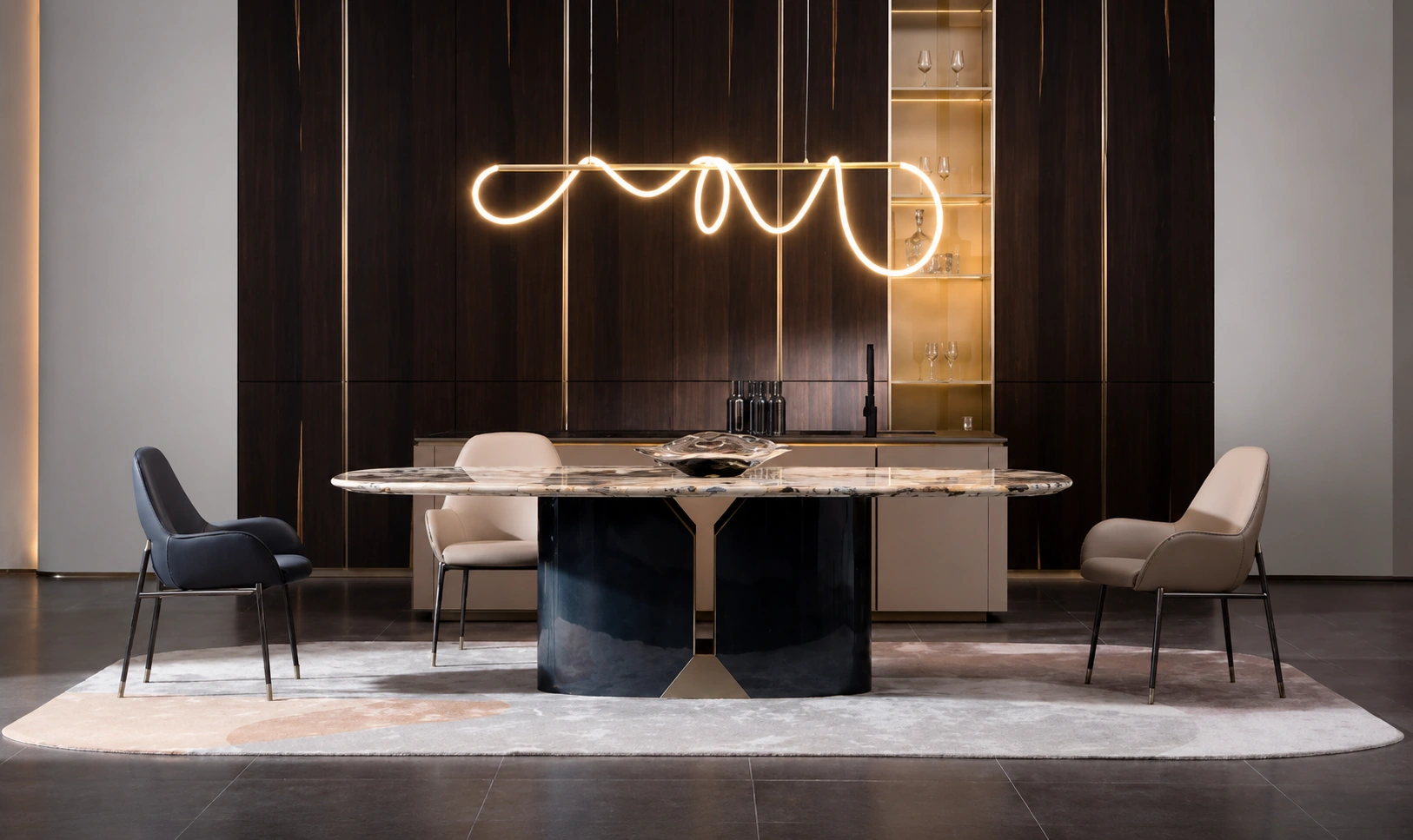 Marble dining table on a black lacquered base beneath a sculptural ribbon light