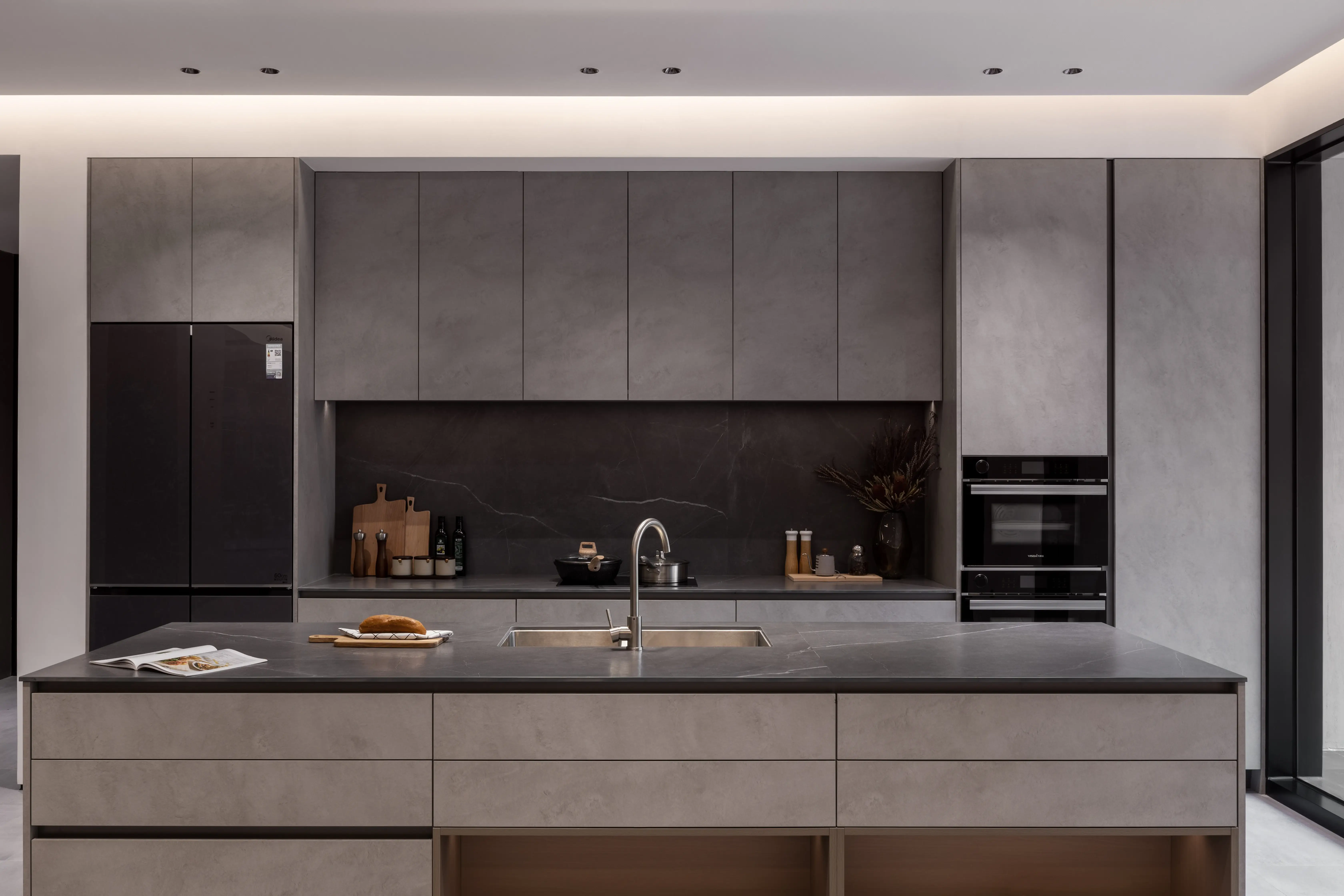 Minimal grey kitchen with a central island and dark marble splashback