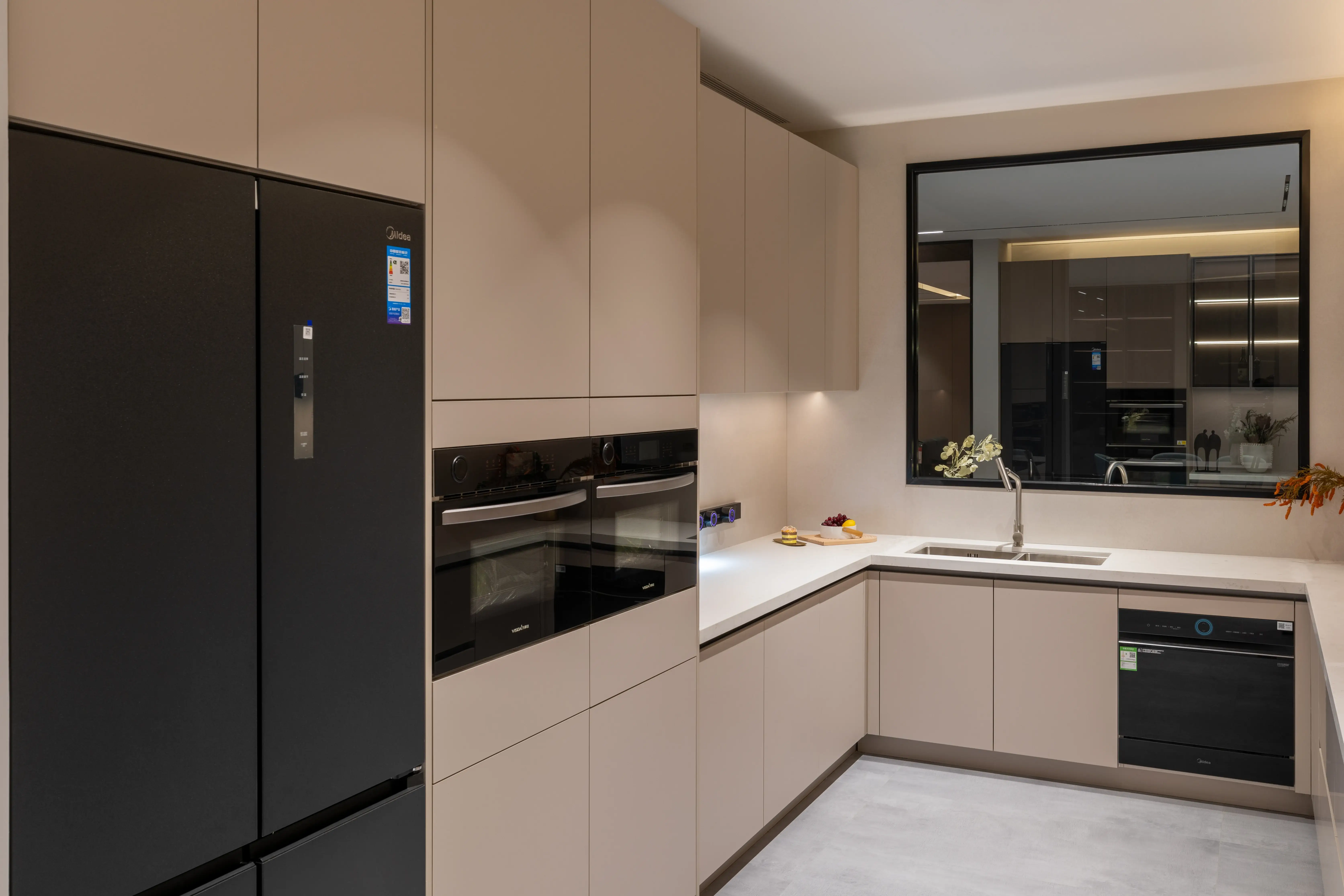 Beige kitchen with a built-in black refrigerator and mirrored wall panel