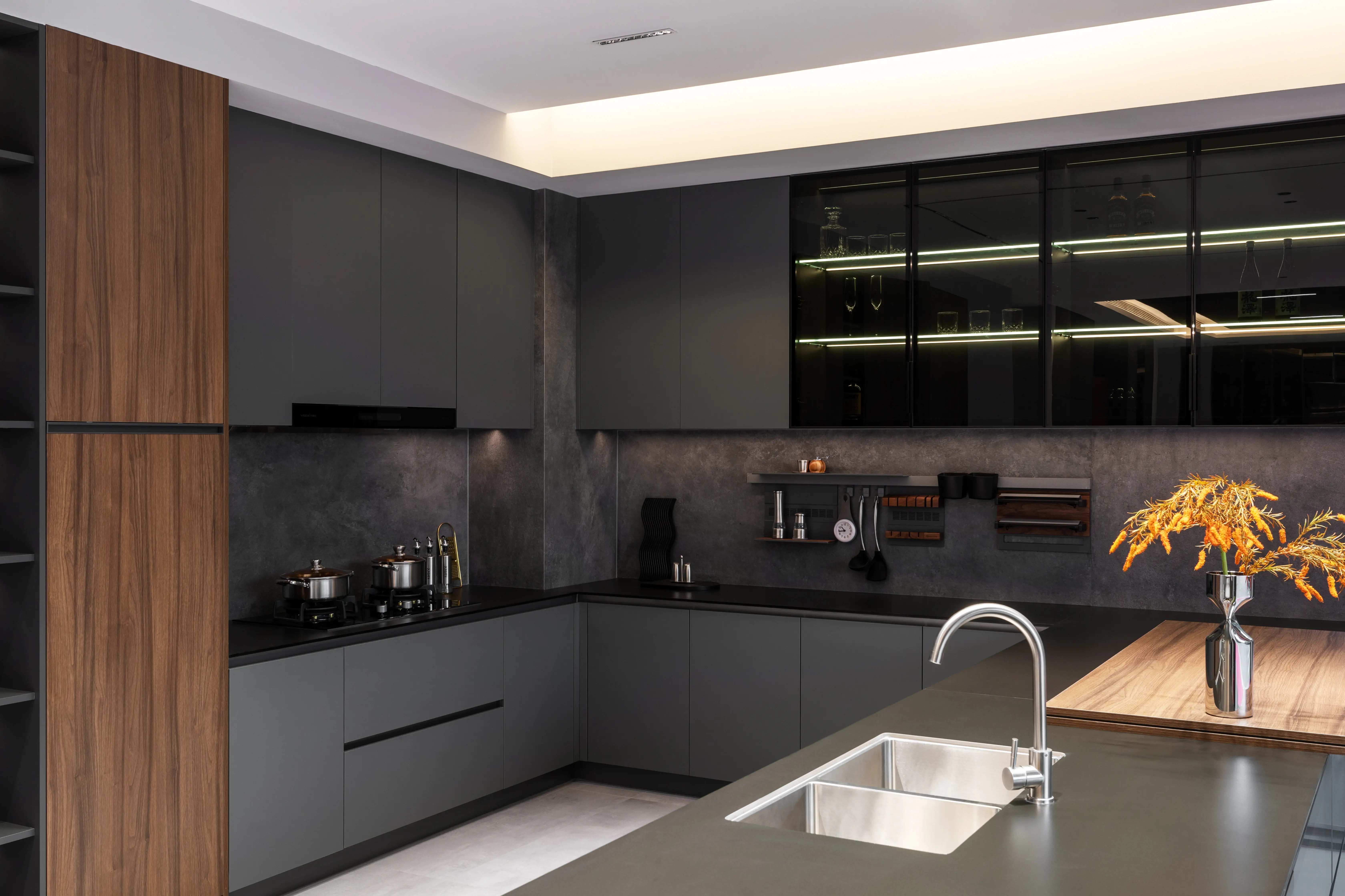 Charcoal and walnut kitchen with dark stone backsplash and golden flowers on the worktop