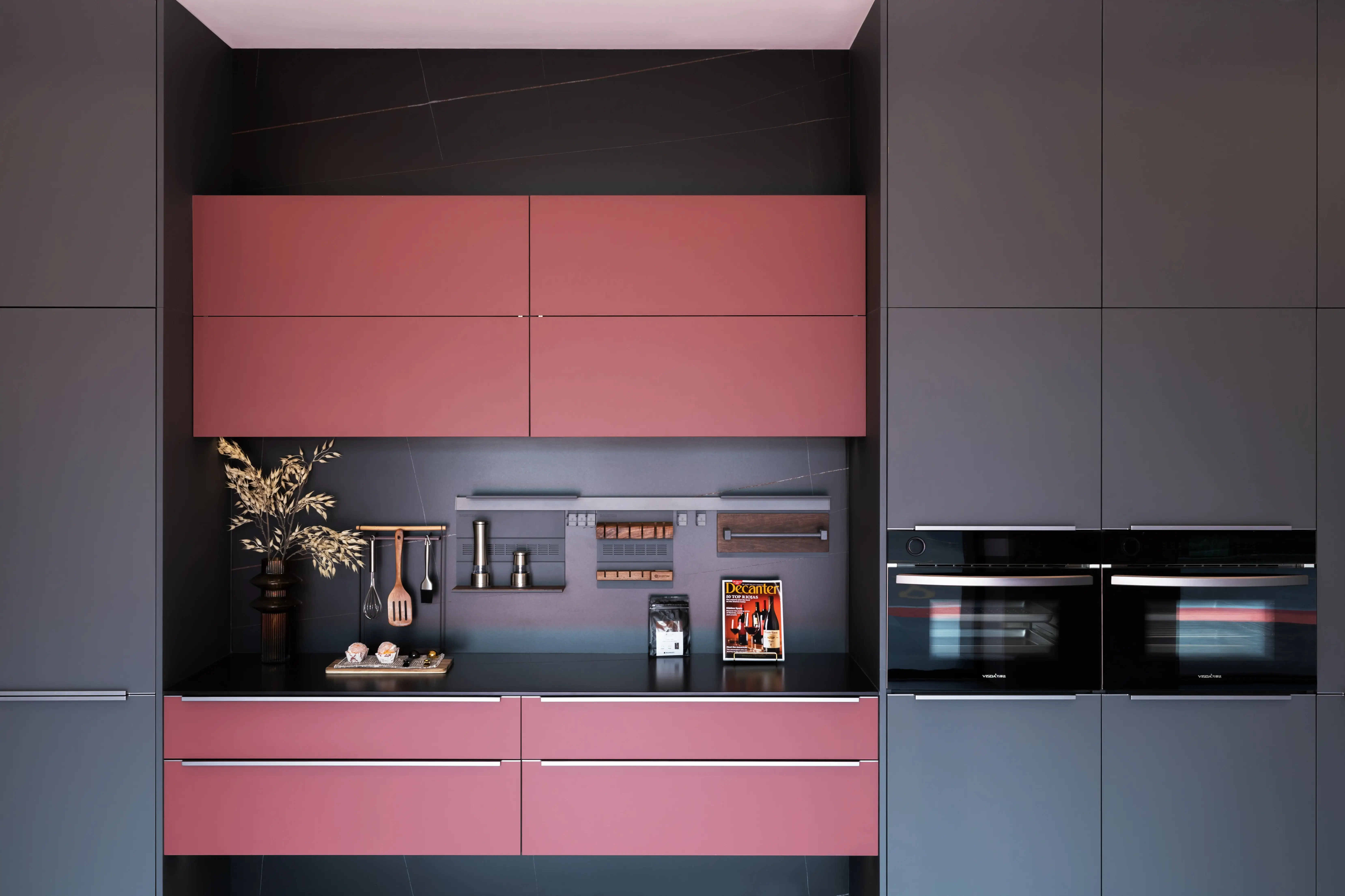Charcoal island kitchen with glass-fronted upper cabinets and warm accent lighting